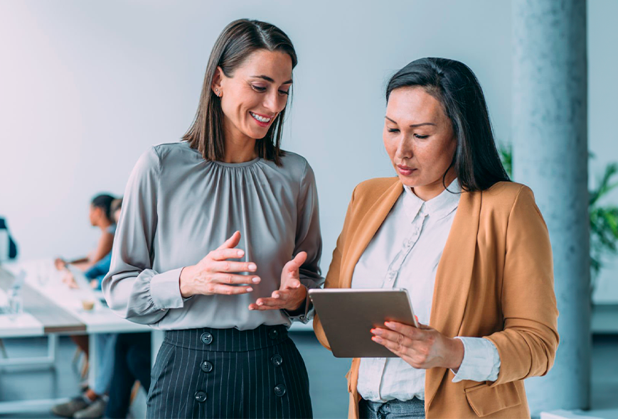 Dos señoras hablando mientras ven un ipad