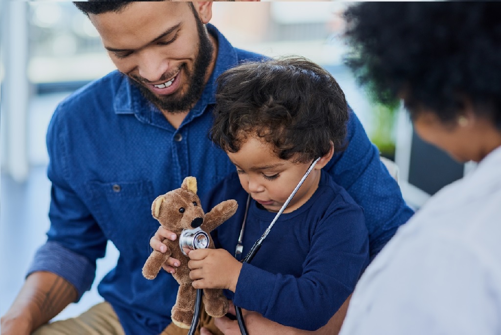 papá con su hijo examinando un oso de peluche
