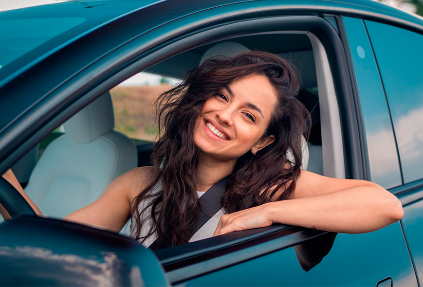 mujer en un carro sonriendo 