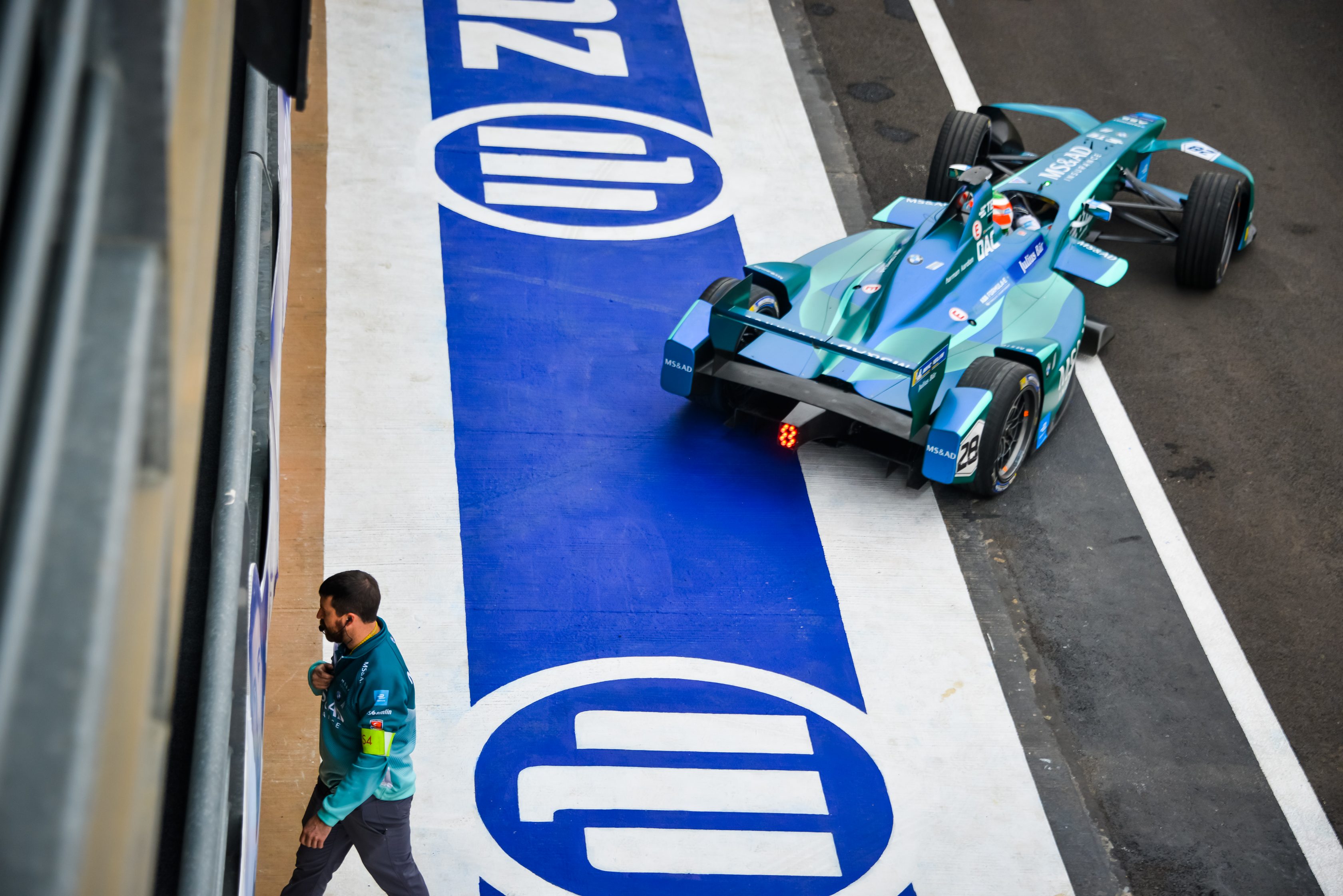 Logo de Allianz Seguros decorando una pista de automovilismo, mientras se desarrolla una carrera de Fórmula E