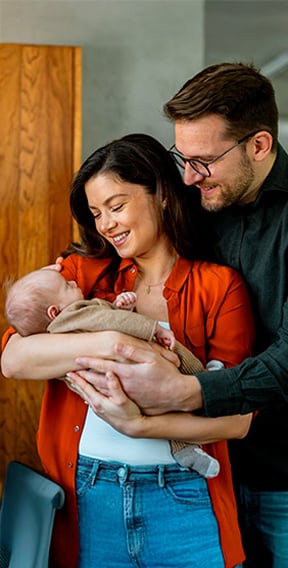 Padres abrazando un bebe