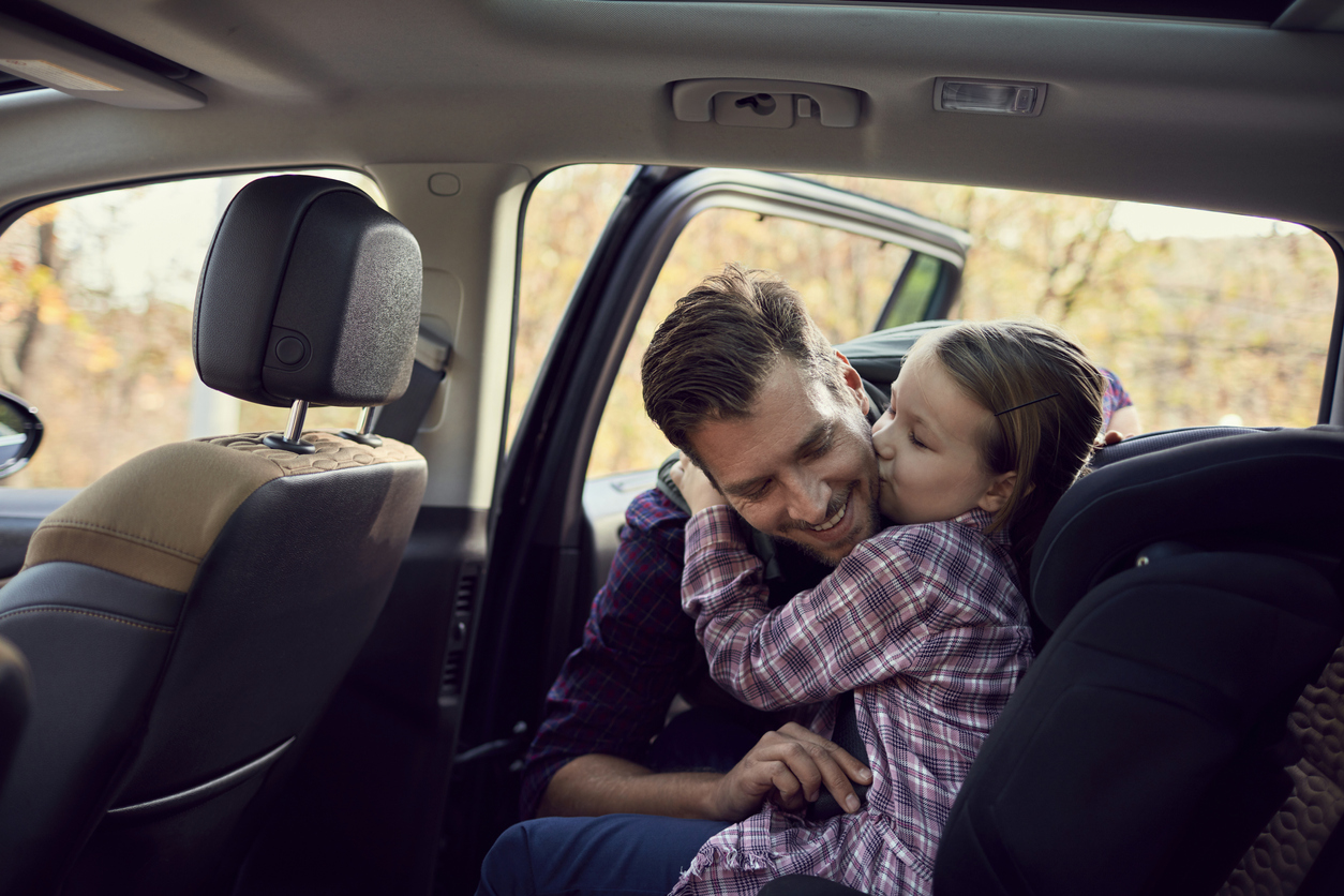 Papá e hija felices en un auto